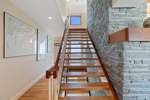 stairway with recessed lighting, wood finished floors, and baseboards