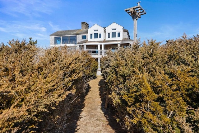 back of house with a chimney