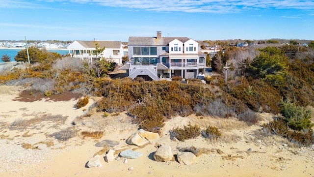 rear view of house with a water view and a chimney