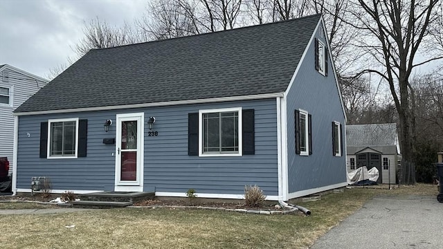 view of front of house featuring a storage unit and a front lawn