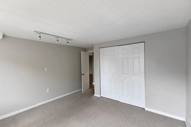 8 9th St Unit 406, Medford, MA 02155 - unfurnished bedroom featuring carpet, a textured ceiling, a closet, and track lighting