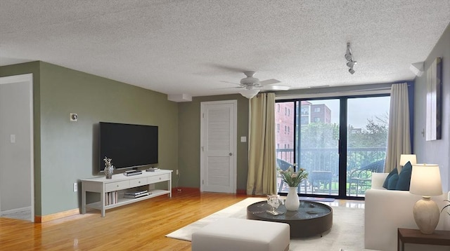 8 9th St Unit 406, Medford, MA 02155 - living room featuring wood finished floors, healthy amount of natural light, rail lighting, and a textured ceiling