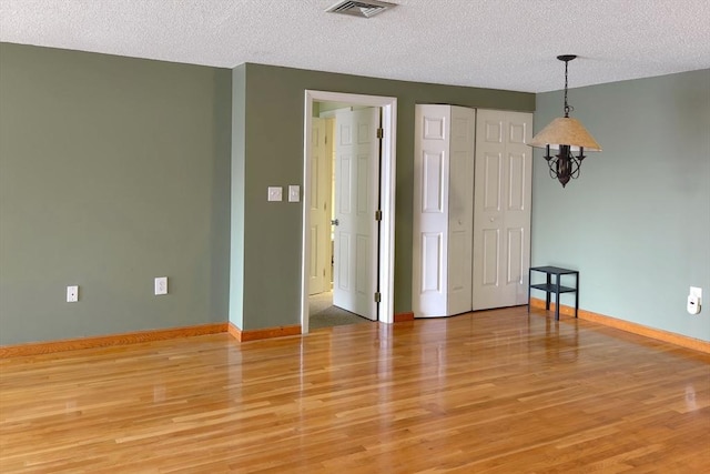8 9th St Unit 406, Medford, MA 02155 - unfurnished room with a textured ceiling and light wood-style floors