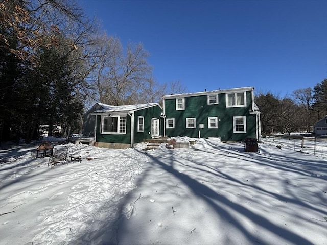 snow covered house featuring crawl space