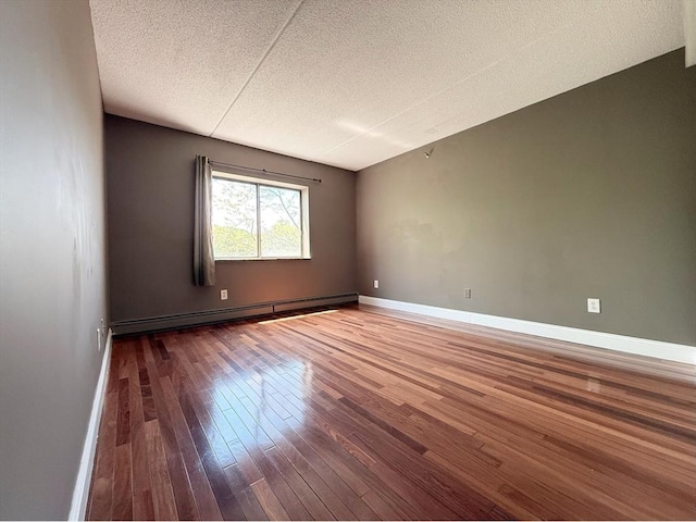 unfurnished room featuring a baseboard radiator, a textured ceiling, hardwood / wood-style flooring, and baseboards