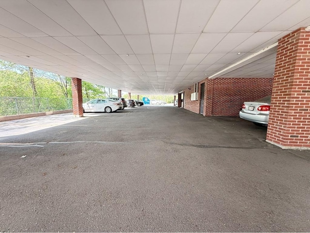 view of vehicle parking featuring a parking deck and fence