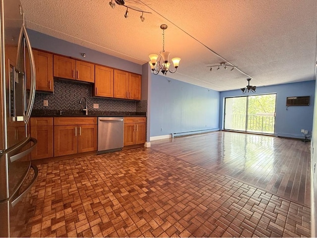 kitchen featuring stainless steel appliances, a chandelier, open floor plan, a textured ceiling, and dark countertops