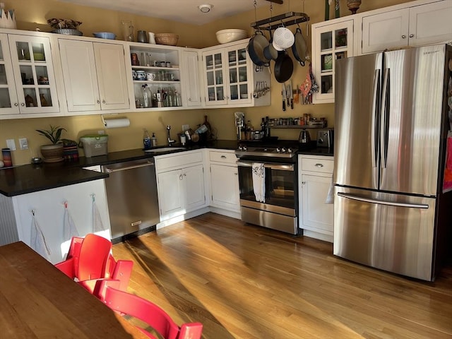 20 Rushmore St Unit 20, Boston, MA 02135 - kitchen featuring stainless steel appliances, dark countertops, wood finished floors, and white cabinets
