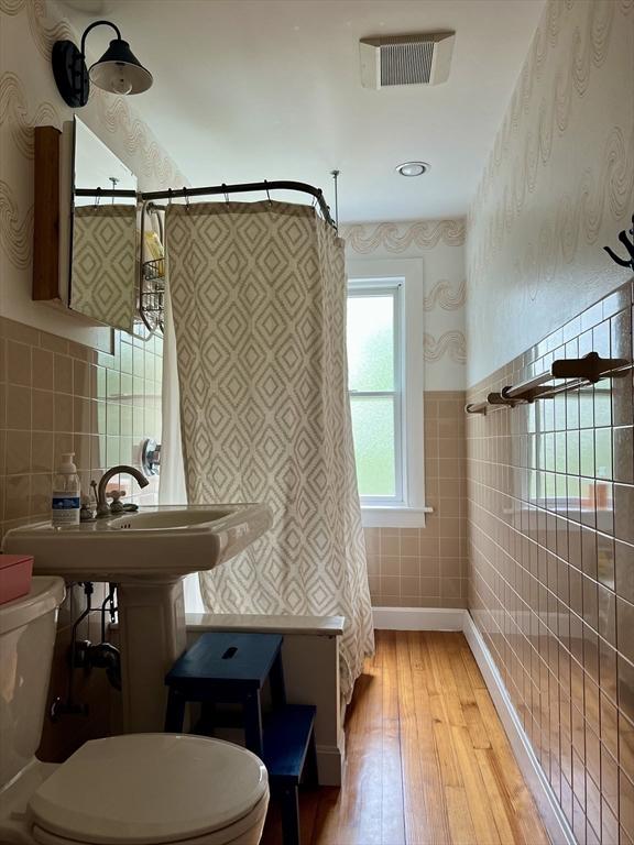 20 Rushmore St Unit 20, Boston, MA 02135 - full bathroom with toilet, tile walls, wallpapered walls, hardwood / wood-style floors, and a shower with curtain