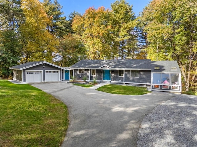 ranch-style home with aphalt driveway, a garage, and a front lawn