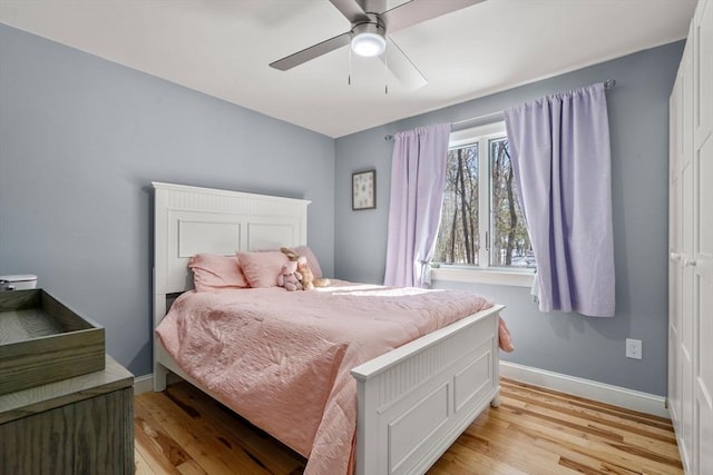 bedroom featuring baseboards, ceiling fan, and light wood-style floors