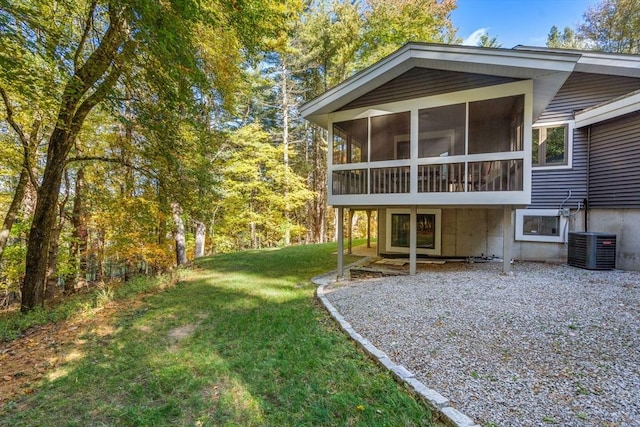 back of house featuring a lawn, cooling unit, and a sunroom