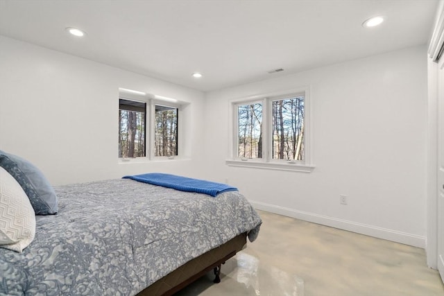 bedroom with finished concrete flooring, visible vents, baseboards, and recessed lighting