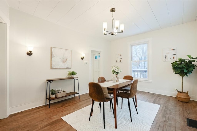 dining space with wood-type flooring and a chandelier