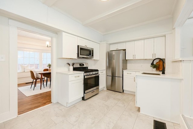 kitchen with stainless steel appliances, white cabinetry, sink, and decorative backsplash