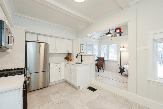 kitchen with white cabinetry, appliances with stainless steel finishes, sink, and kitchen peninsula