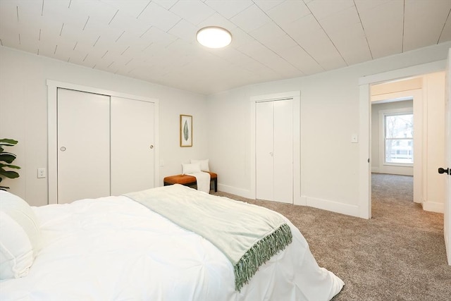 bedroom featuring two closets and light carpet