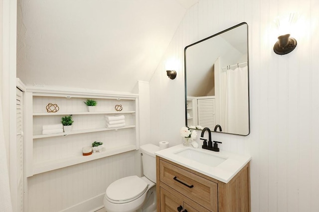 bathroom featuring vanity, toilet, and vaulted ceiling