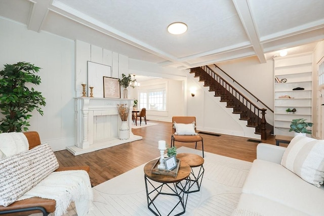 living room with beamed ceiling, wood-type flooring, and coffered ceiling