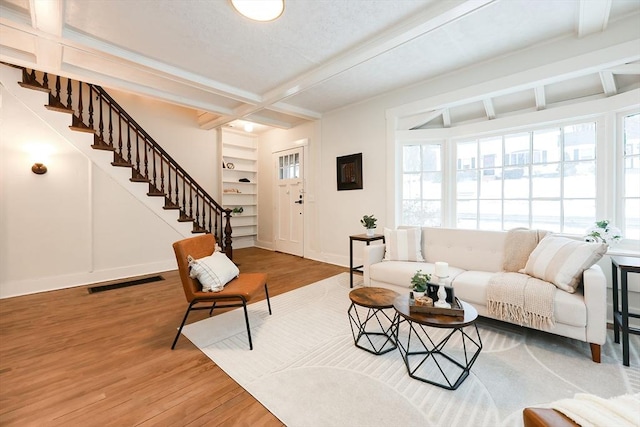 living room with coffered ceiling, hardwood / wood-style floors, and beam ceiling