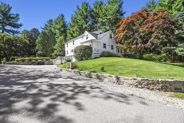 view of home's exterior with aphalt driveway and a yard