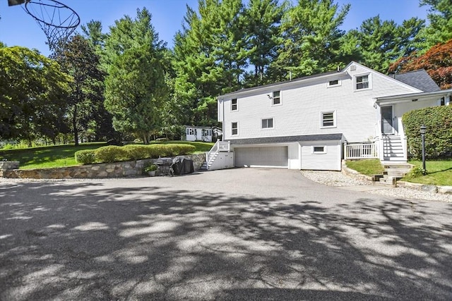 view of property exterior with an attached garage and driveway