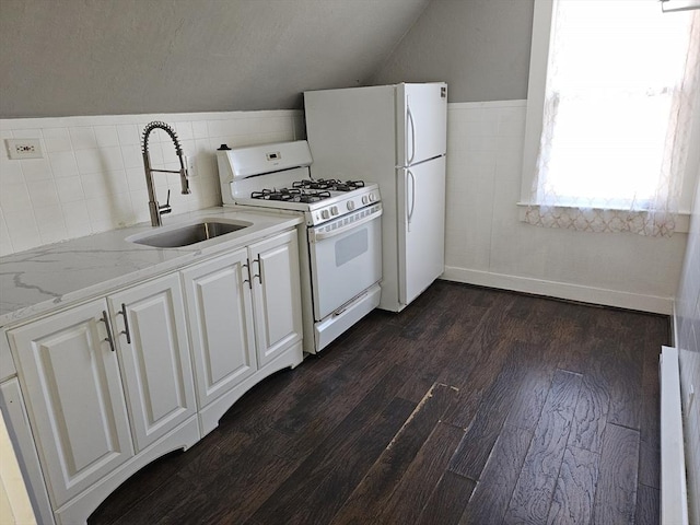 kitchen featuring white gas stove, a sink, dark wood finished floors, white cabinetry, and lofted ceiling