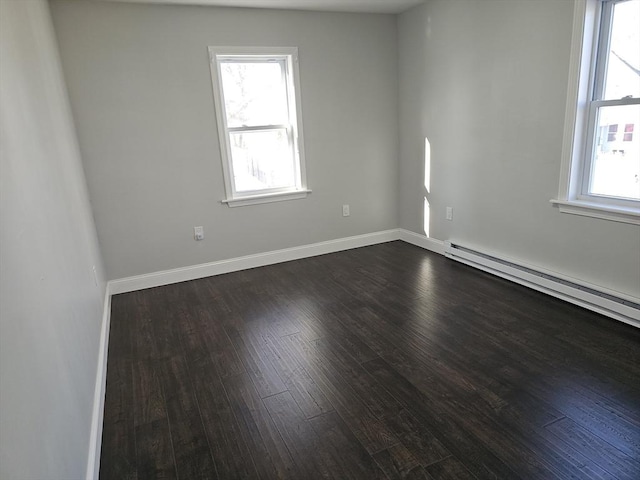 spare room featuring dark wood-style floors, baseboards, and a baseboard radiator