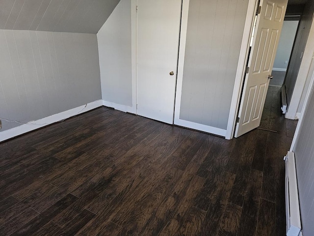 bonus room with baseboard heating, dark wood-type flooring, baseboards, and vaulted ceiling