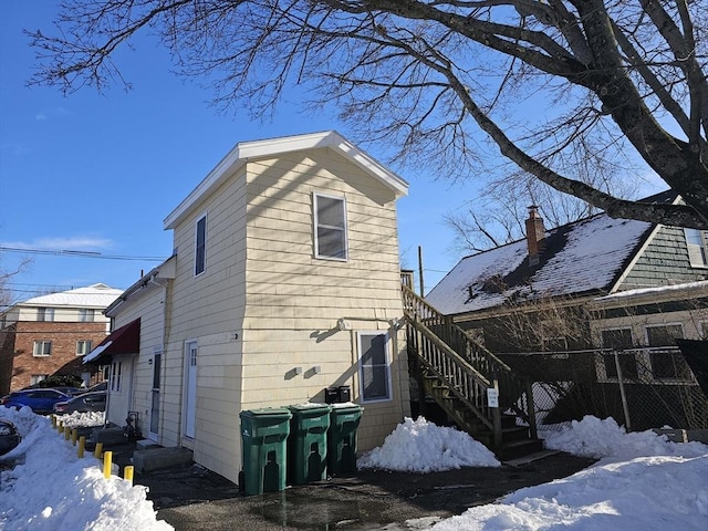 view of snowy exterior featuring stairway and entry steps