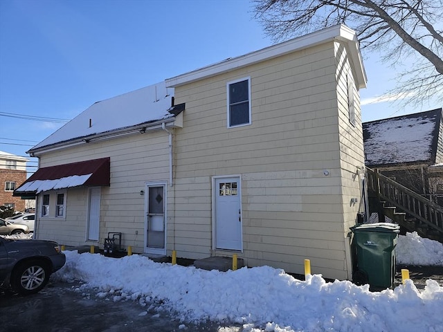 view of snow covered rear of property