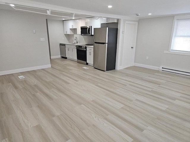 kitchen featuring baseboards, light wood-style floors, white cabinets, stainless steel appliances, and a baseboard radiator