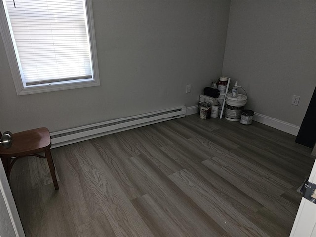 spare room featuring baseboards, baseboard heating, and wood finished floors