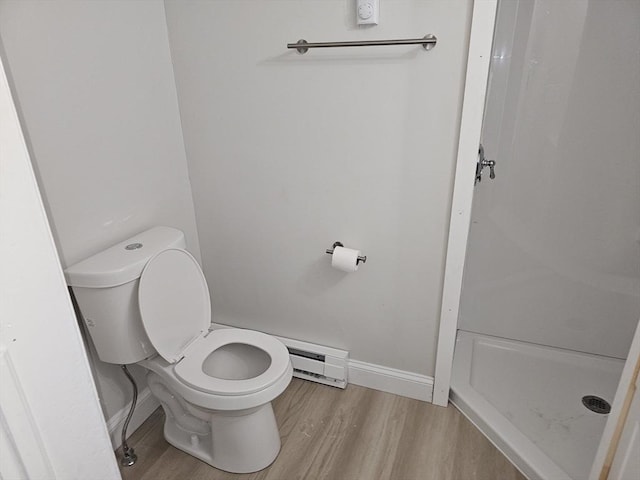 bathroom with toilet, a stall shower, wood finished floors, and a baseboard radiator