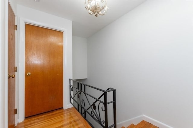 57 Saint Paul St Unit 19, Brookline, MA 02445 - corridor featuring an upstairs landing, light wood finished floors, baseboards, and a chandelier
