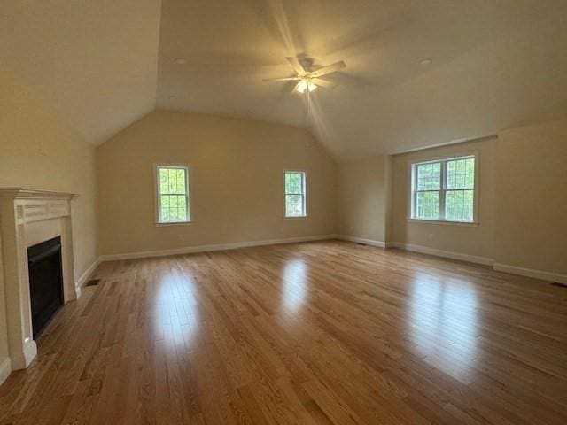 70 Kilburn St, Lunenburg, MA 01462 - unfurnished living room featuring wood finished floors, a fireplace, vaulted ceiling, a ceiling fan, and baseboards