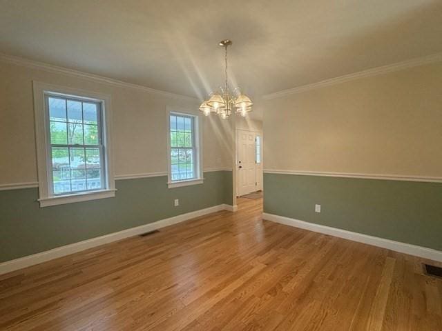 70 Kilburn St, Lunenburg, MA 01462 - unfurnished dining area featuring a chandelier, ornamental molding, wood finished floors, and baseboards