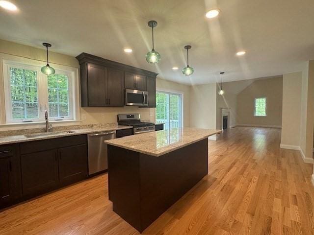 70 Kilburn St, Lunenburg, MA 01462 - kitchen featuring stainless steel appliances, light stone counters, light wood-type flooring, a center island, and recessed lighting