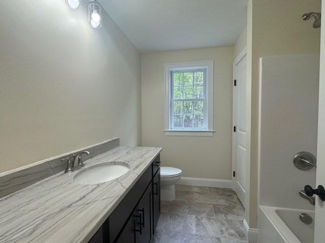 70 Kilburn St, Lunenburg, MA 01462 - bathroom featuring vanity, toilet, baseboards, and bathtub / shower combination