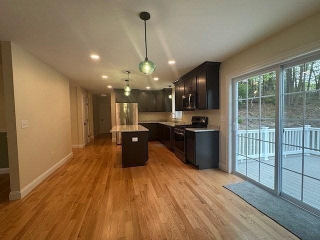 70 Kilburn St, Lunenburg, MA 01462 - kitchen featuring appliances with stainless steel finishes, light wood-style floors, a center island, baseboards, and light countertops