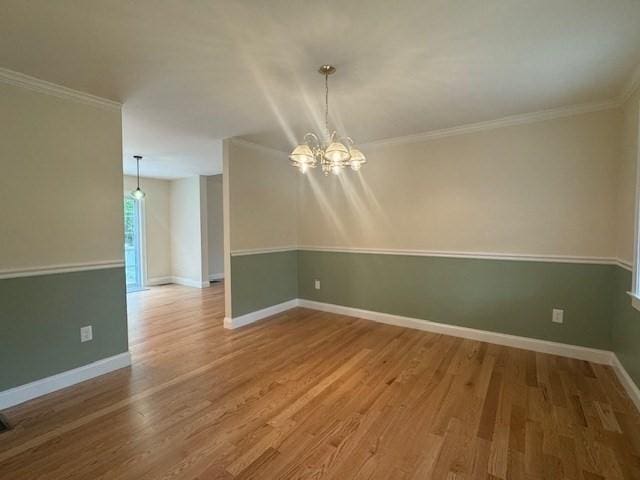 70 Kilburn St, Lunenburg, MA 01462 - empty room featuring wood finished floors, a chandelier, baseboards, and ornamental molding