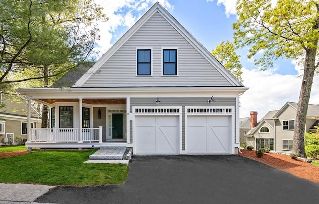 view of front of house with a porch, a garage, and a front lawn