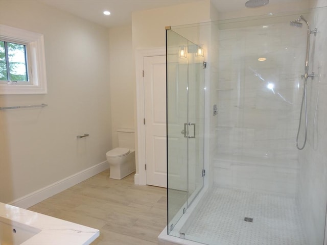 bathroom featuring vanity, hardwood / wood-style floors, a shower with shower door, and toilet