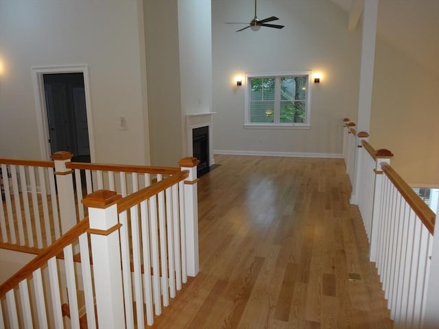 hallway with light hardwood / wood-style flooring and high vaulted ceiling