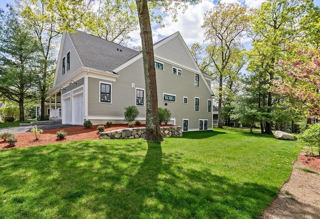 view of side of home with a yard and a garage