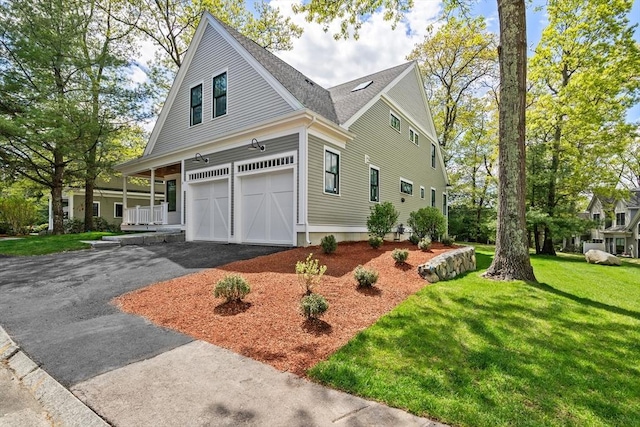 view of front facade featuring a porch, a garage, and a front lawn