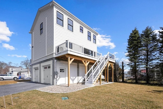 view of front of house with a garage, a deck, and a front lawn