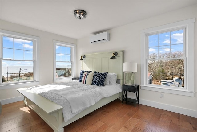 bedroom with hardwood / wood-style flooring and an AC wall unit