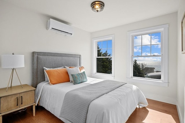 bedroom with wood-type flooring and a wall mounted AC