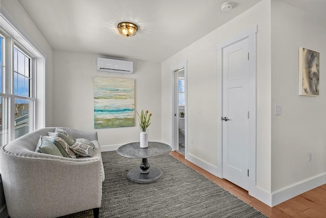 sitting room with wood-type flooring and a wall mounted AC